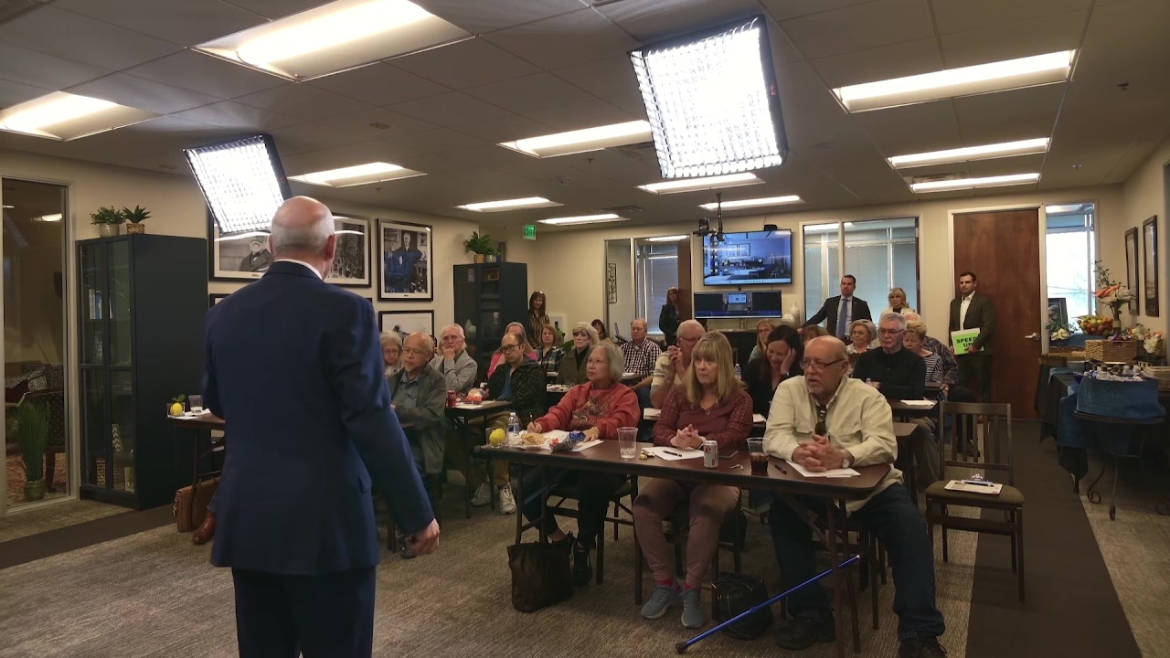 David Schaeffer addressing an afternoon workshop while a staffer holds a hand-lettered SPEAK UP sign at the back