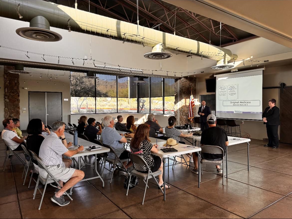 A community-center workshop at sunset, desert visible through the windows